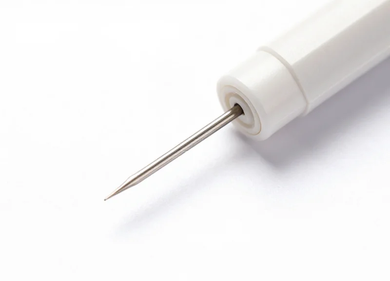 Macro shot of a specialized fine-needle EAS security tag on a white background.