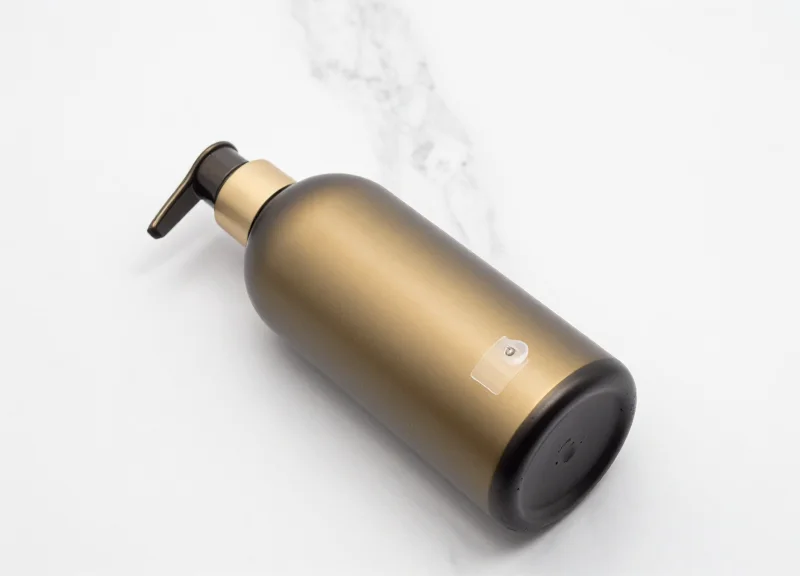 Luxury hair care product with a discreet integrated EAS security tag on a marble surface.