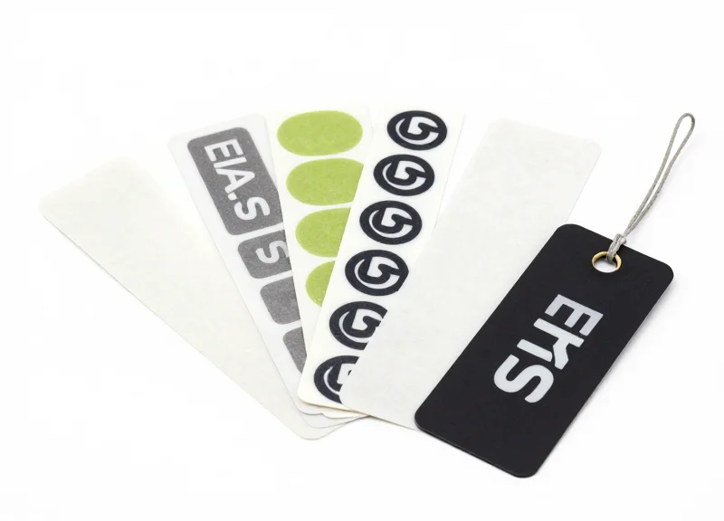 A collection of EAS soft labels and hard tags shown on a clean white background.