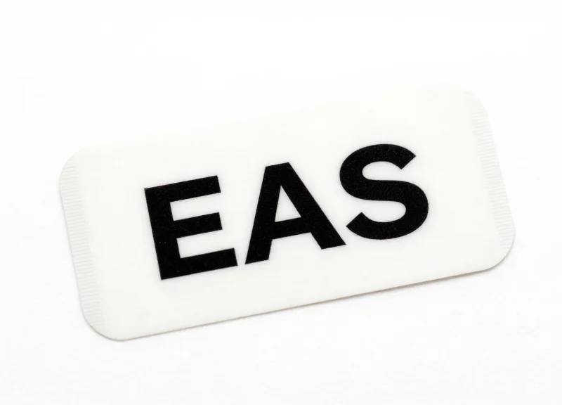 A close-up of a specialized security EAS label designed for adhesive application on pet food packaging.