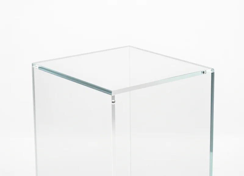 A close-up shot of a minimalist clear acrylic EAS security pedestal with modern design details.