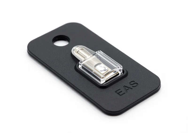 Macro shot of a modern EAS optical security tag on a white background.