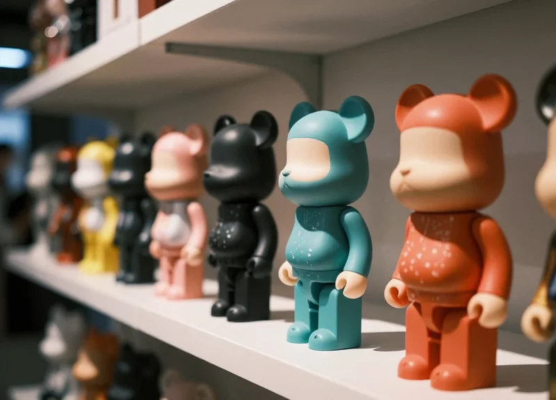 Close-up of high-end designer vinyl toys displayed in a trendy modern retail store.