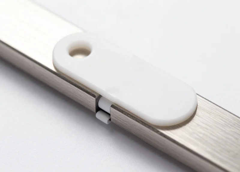 Close-up shot of a white AM security tag separated from a metal surface by a small foam air gap.
