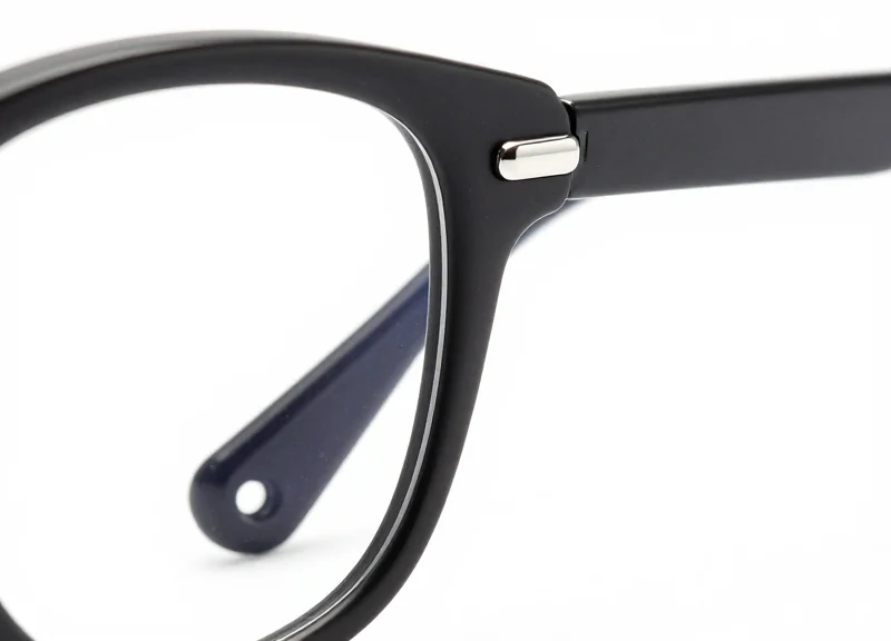 Macro shot of a luxury eyeglass frame temple with a sleek security tag.