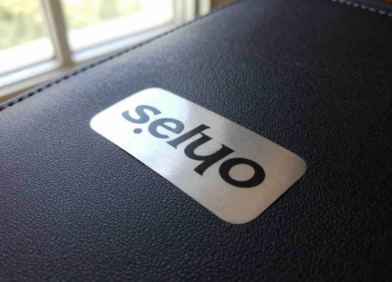 Macro photography of a security sticker being applied to a premium leather texture