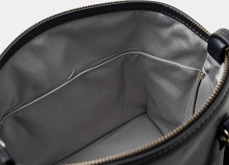 Close-up of a high-end luxury handbag with a discreet integrated security sensor