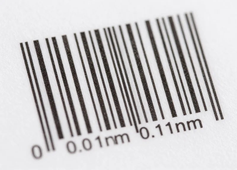 Extreme macro view of a high-density barcode label showcasing 0.1mm precision lines.