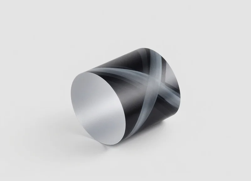 A close-up photograph of a thin, flexible E-ink display panel smoothly curved around a 15mm radius surface, featuring a matte texture and abstract grayscale patterns.