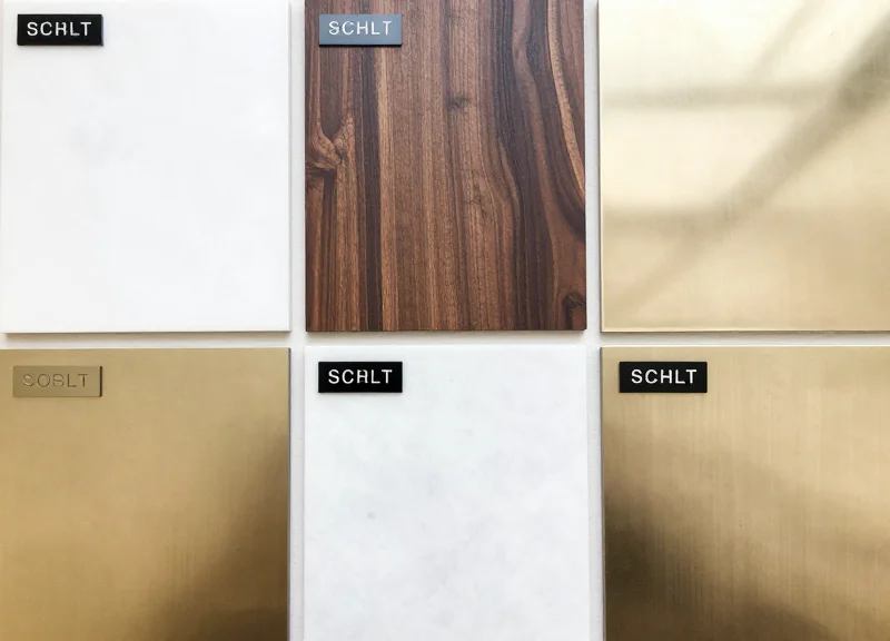 Top-down view of several electronic shelf labels arranged on marble, wood, and metal material samples.